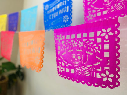 Multicolor Día de los Muertos papel picado banner with skull and floral cutouts